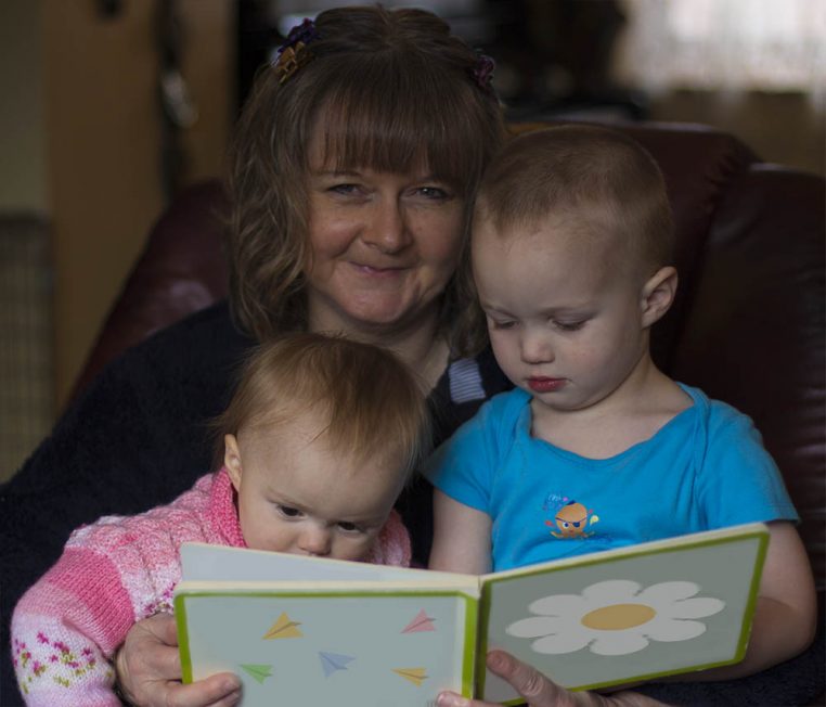 SuzieW, children's author, is reading a picture book to toddlers.